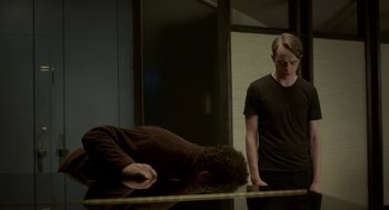 Movie still from “Life After Beth” (2014), directed by Jeff Baena – A man standing next to another man in a room; Medium shot, High angle