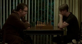 Movie still from “Life After Beth” (2014), directed by Jeff Baena – Two people sitting at a table playing a game of chess; Medium shot, Over the shoulder angle
