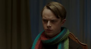 Movie still from “Life After Beth” (2014), directed by Jeff Baena – A man wearing a colorful scarf and a black shirt; Close Up shot, Over the shoulder angle