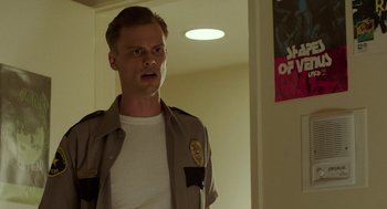 Movie still from “Life After Beth” (2014), directed by Jeff Baena – A man in a uniform standing next to a door; Close Up shot, Low angle