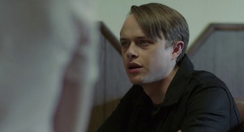 Movie still from “Life After Beth” (2014), directed by Jeff Baena – A young man sitting in front of a mirror looking at the camera; Close Up shot, Over the shoulder angle