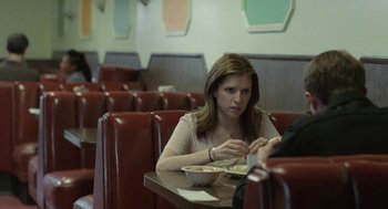 Movie still from “Life After Beth” (2014), directed by Jeff Baena – A woman sitting at a table with a bowl of food; Medium shot, Over the shoulder angle