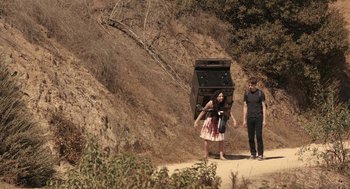 Movie still from “Life After Beth” (2014), directed by Jeff Baena – Two people walking down a dirt road near a hill; Wide shot, High angle
