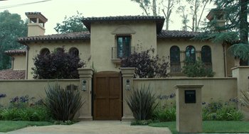 Movie still from “Life After Beth” (2014), directed by Jeff Baena – A tan building with a brown door and a window; Extreme Wide shot, Low angle