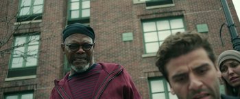 Movie still from “Life Itself” (2018), directed by Dan Fogelman – A man in a striped shirt standing in front of a brick building; Close Up shot, Low angle