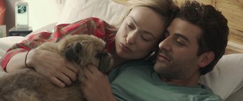Movie still from “Life Itself” (2018), directed by Dan Fogelman – A man and a woman laying in a bed with a dog; Close Up shot, Overhead angle