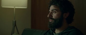Movie still from “Life Itself” (2018), directed by Dan Fogelman – A man with a beard sitting on a couch looking to his left; Close Up shot, Over the shoulder angle