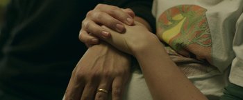 Movie still from “Life Itself” (2018), directed by Dan Fogelman – A man and a woman holding hands with a tattoo on their right arm; Extreme Close Up shot, Overhead angle