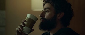 Movie still from “Life Itself” (2018), directed by Dan Fogelman – A man with a beard is holding a cup of coffee; Close Up shot, Over the shoulder angle