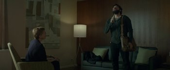 Movie still from “Life Itself” (2018), directed by Dan Fogelman – A man standing in front of a lamp in a living room; Medium shot, Over the shoulder angle