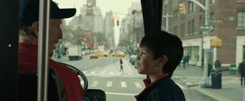 Movie still from “Life Itself” (2018), directed by Dan Fogelman – A young boy riding in a bus on a city street; Medium shot, Over the shoulder angle