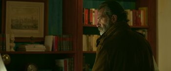 Movie still from “Life Itself” (2018), directed by Dan Fogelman – A man standing in front of a book shelf; Medium shot, Over the shoulder angle