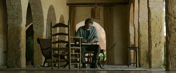 Movie still from “Life Itself” (2018), directed by Dan Fogelman – An older man sitting at a table in a living room; Wide shot, Low angle