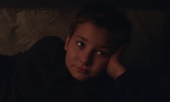 Movie still from “Light of My Life” (2019), directed by Casey Affleck – A young boy is sitting in a dark room; Close Up shot, High angle