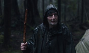Movie still from “Light of My Life” (2019), directed by Casey Affleck – A man holding a wooden stick in the rain; Close Up shot, Low angle