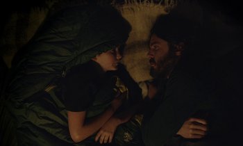Movie still from “Light of My Life” (2019), directed by Casey Affleck – A man laying next to a woman in a bed; Medium shot, Overhead angle