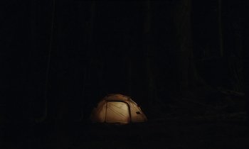 Movie still from “Light of My Life” (2019), directed by Casey Affleck – A tent in the dark in the woods; Extreme Wide shot, High angle