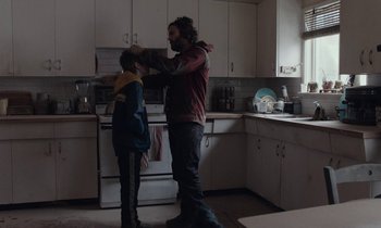 Movie still from “Light of My Life” (2019), directed by Casey Affleck – A man and a boy in a kitchen; Medium shot, Over the shoulder angle