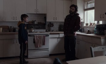 Movie still from “Light of My Life” (2019), directed by Casey Affleck – Two people standing in a kitchen next to each other; Medium shot, Over the shoulder angle