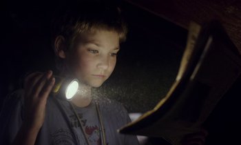 Movie still from “Light of My Life” (2019), directed by Casey Affleck – A young boy holding a flashlight in front of a mirror; Close Up shot, Low angle