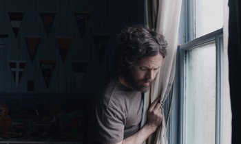 Movie still from “Light of My Life” (2019), directed by Casey Affleck – A man standing in front of a window looking out of the window; Medium shot, Low angle