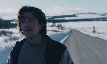Movie still from “Light of My Life” (2019), directed by Casey Affleck – A man standing on the side of a road in the snow; Close Up shot, Over the shoulder angle
