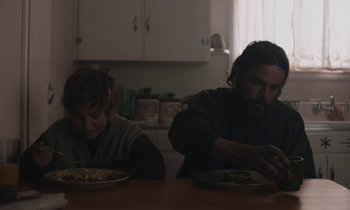 Movie still from “Light of My Life” (2019), directed by Casey Affleck – A man and a woman sitting at a table eating food; Medium shot, Over the shoulder angle