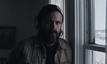 Movie still from “Light of My Life” (2019), directed by Casey Affleck – A man with long hair and a beard looking out a window; Close Up shot, Low angle