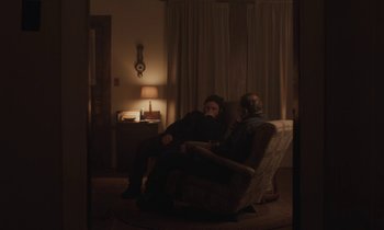 Movie still from “Light of My Life” (2019), directed by Casey Affleck – Two people sitting in a chair in the dark; Wide shot, Over the shoulder angle