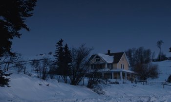 Movie still from “Light of My Life” (2019), directed by Casey Affleck – A yellow house sitting on top of a snow covered hill; Extreme Wide shot, Low angle