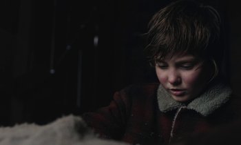 Movie still from “Light of My Life” (2019), directed by Casey Affleck – A young boy in a red jacket looking down at snow; Close Up shot, Over the shoulder angle