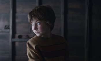 Movie still from “Light of My Life” (2019), directed by Casey Affleck – A young boy in a striped sweater looks at the camera; Close Up shot, High angle