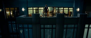 Movie still from “Limitless” (2011), directed by Neil Burger – A man in a suit standing on a balcony; Extreme Wide shot, Overhead angle