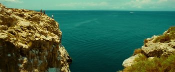 Movie still from “Limitless” (2011), directed by Neil Burger – A person standing on a cliff overlooking the ocean; Extreme Wide shot, Low angle