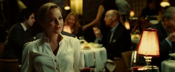 Movie still from “Limitless” (2011), directed by Neil Burger – A woman sitting at a table with a glass of red wine; Medium shot, Over the shoulder angle
