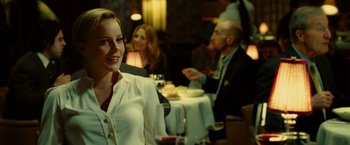 Movie still from “Limitless” (2011), directed by Neil Burger – A woman sitting at a table with a glass of red wine; Medium shot, Over the shoulder angle