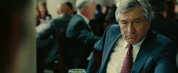Movie still from “Limitless” (2011), directed by Neil Burger – An older man in a suit and tie sitting at a table; Close Up shot, Over the shoulder angle