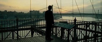 Movie still from “Limitless” (2011), directed by Neil Burger – A man standing on a deck looking out at a bridge; Wide shot, Low angle