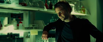 Movie still from “Limitless” (2011), directed by Neil Burger – A man leaning on a shelf in front of a wall; Close Up shot, Low angle