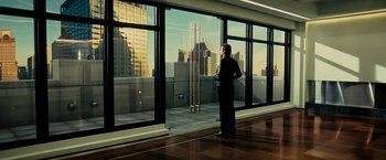 Movie still from “Limitless” (2011), directed by Neil Burger – A man standing in front of a large glass window; Wide shot, Low angle