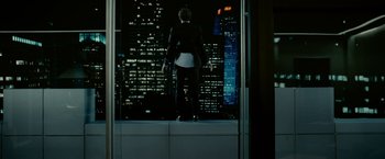 Movie still from “Limitless” (2011), directed by Neil Burger – A man standing on a window ledge looking out at a city; Wide shot, Low angle