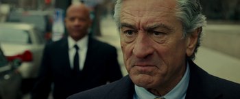 Movie still from “Limitless” (2011), directed by Neil Burger – An older man wearing a suit and tie looking sad; Close Up shot, Over the shoulder angle