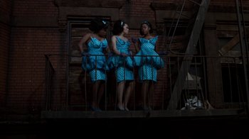 Movie still from “Little Shop of Horrors” (1986), directed by Frank Oz – A group of women in blue dresses standing next to each other; Wide shot, Low angle