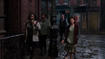 Movie still from “Little Shop of Horrors” (1986), directed by Frank Oz – A group of people standing on the side of a street; Wide shot, High angle