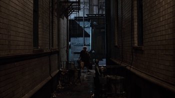 Movie still from “Little Shop of Horrors” (1986), directed by Frank Oz – A person walking down a dark alleyway; Extreme Wide shot, High angle