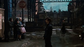 Movie still from “Little Shop of Horrors” (1986), directed by Frank Oz – A group of people standing on the sidewalk; Wide shot, Over the shoulder angle