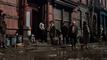 Movie still from “Little Shop of Horrors” (1986), directed by Frank Oz – A group of people walking down the steps of a building; Wide shot, High angle