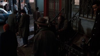 Movie still from “Little Shop of Horrors” (1986), directed by Frank Oz – A group of people sitting on steps in the dark; Wide shot, High angle