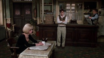 Movie still from “Little Shop of Horrors” (1986), directed by Frank Oz – A man and a woman sitting at a table in a room; Medium shot, Over the shoulder angle