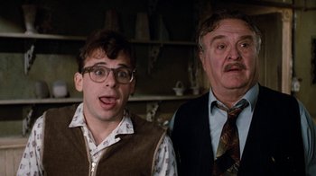 Movie still from “Little Shop of Horrors” (1986), directed by Frank Oz – A man and a man in a room with shelves; Close Up shot, Low angle
